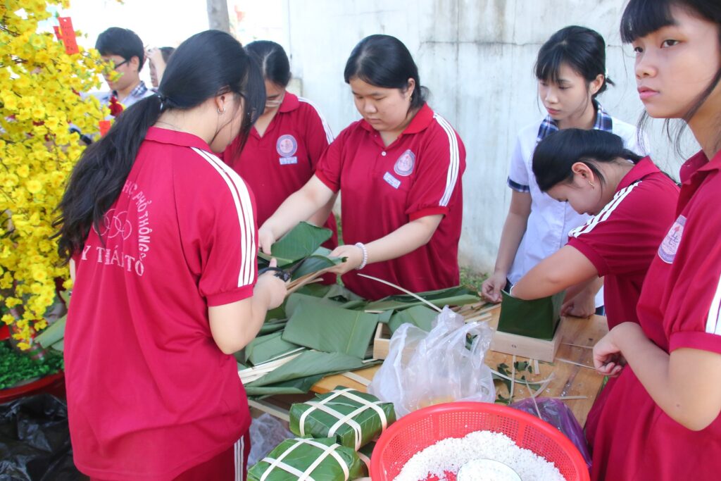 Học sinh gói bánh chưng bánh tét trong hội xuân.