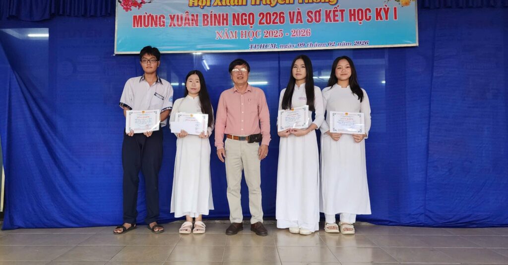 Thầy hiệu trưởng phát thưởng cho học sinh xuất sắc.