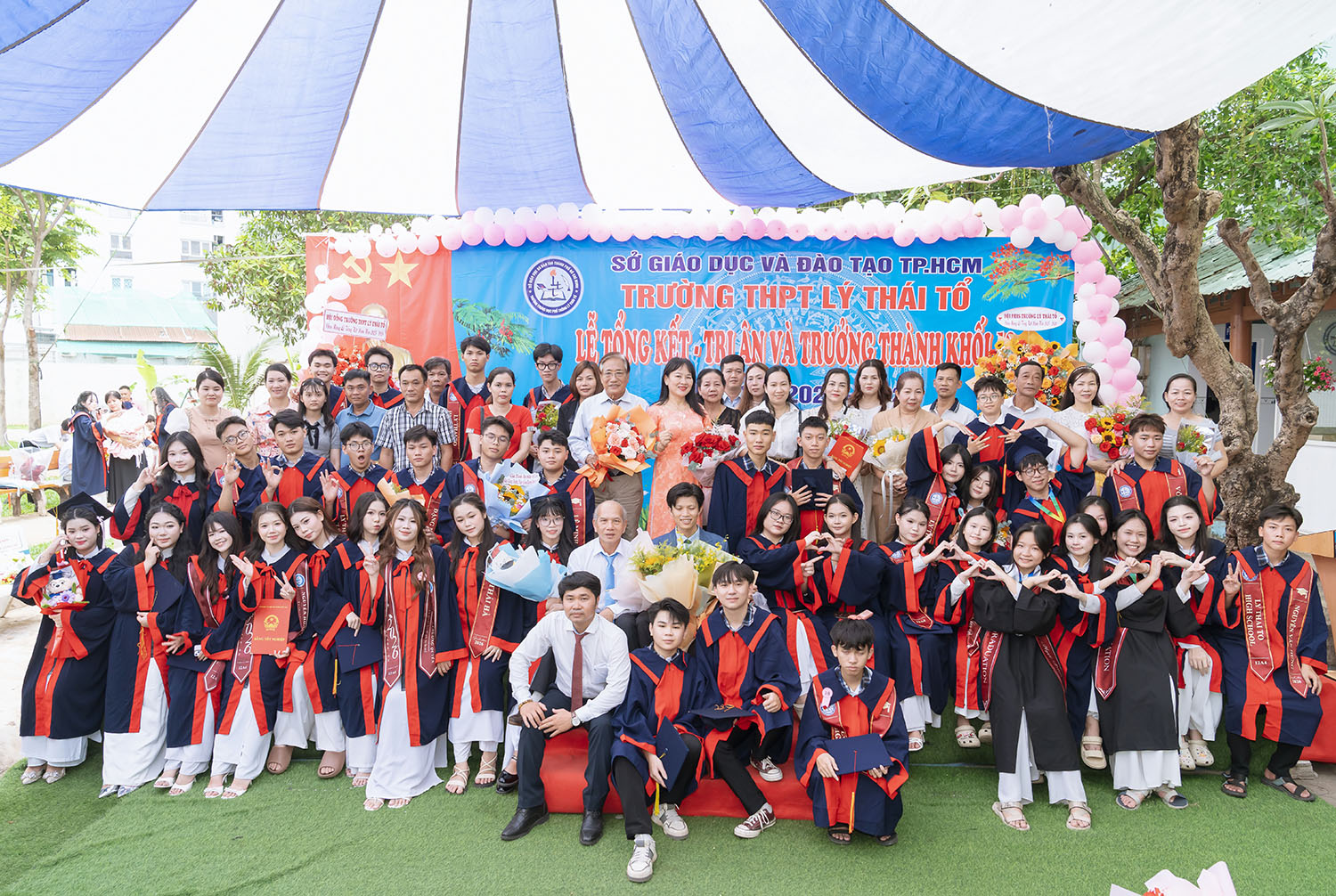 Học sinh lớp 12A4 chụp ảnh cùng thầy cô, phụ huynh và Hội đồng trường trong lễ tri ân trưởng thành